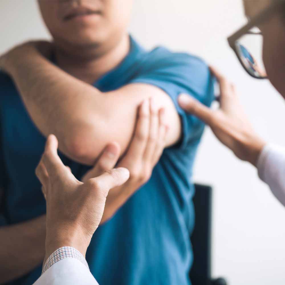 Man with painful arm being examines by clinician