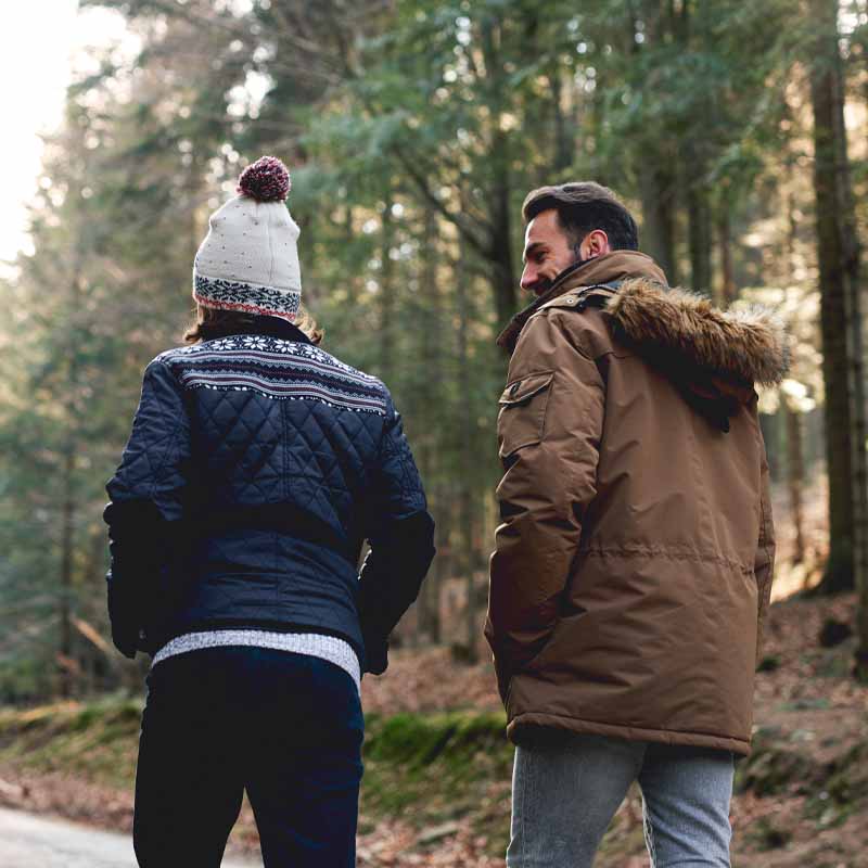 Couple walking along woodland path