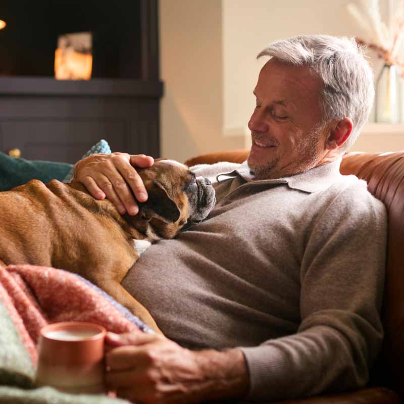 Man reclining on couch with dog