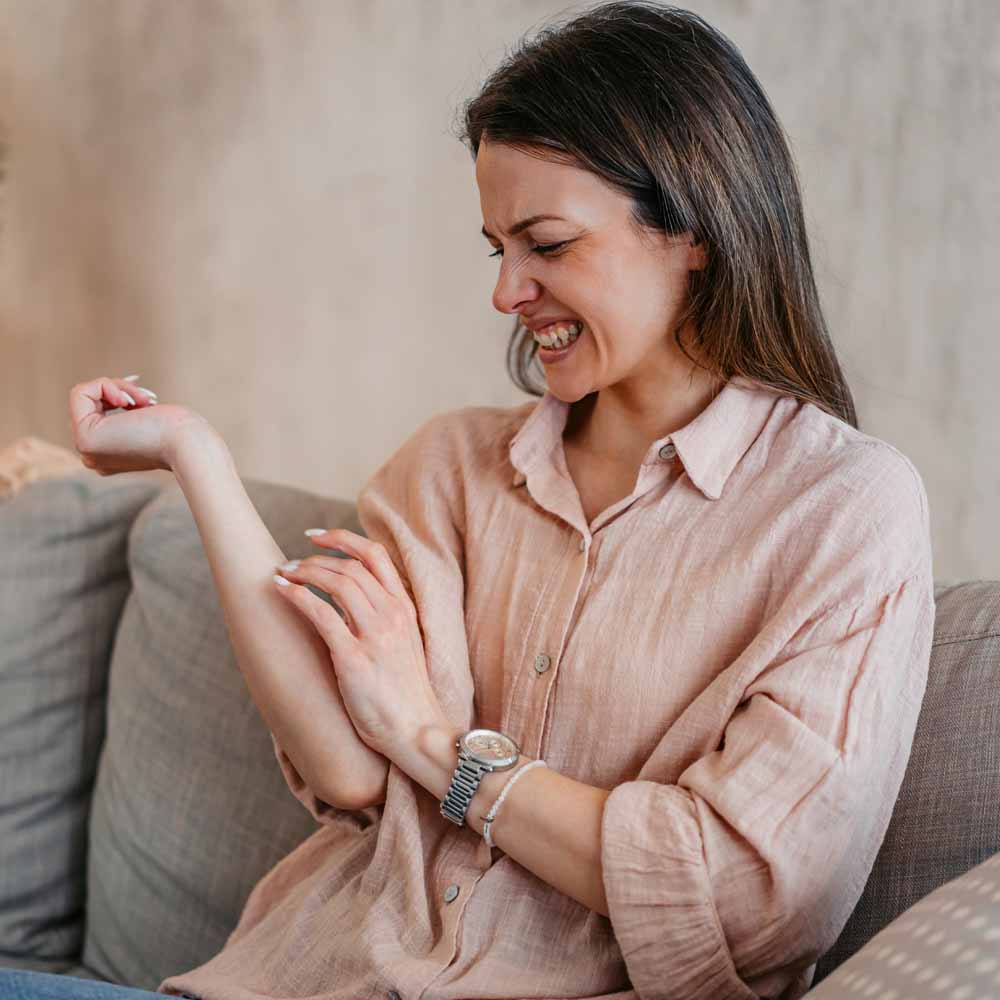 Young woman scratching her skin