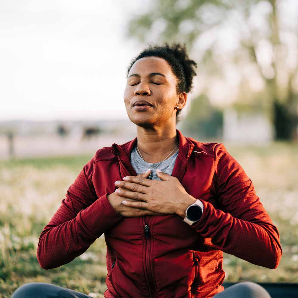 Woman breathing with hands on chest for meditation and wellness